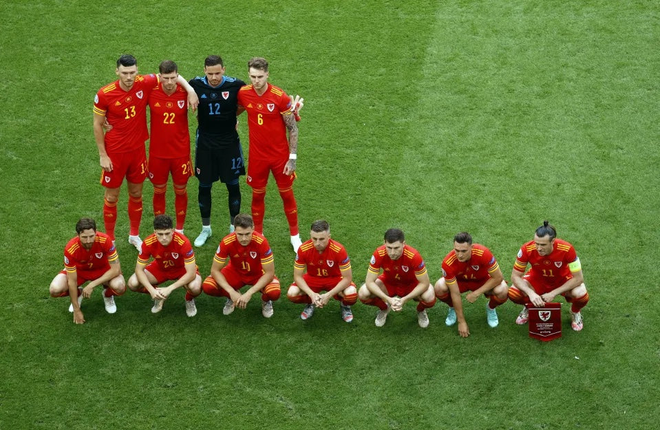 Wales players line up for their trademark lopsided pre-match team photo at Euro 2016, the whole squad bunched to one side of the pitch, Made in Cymru