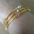 3 strand gold toned memory wire bangle with champagne & gold beads, 6cm diameter