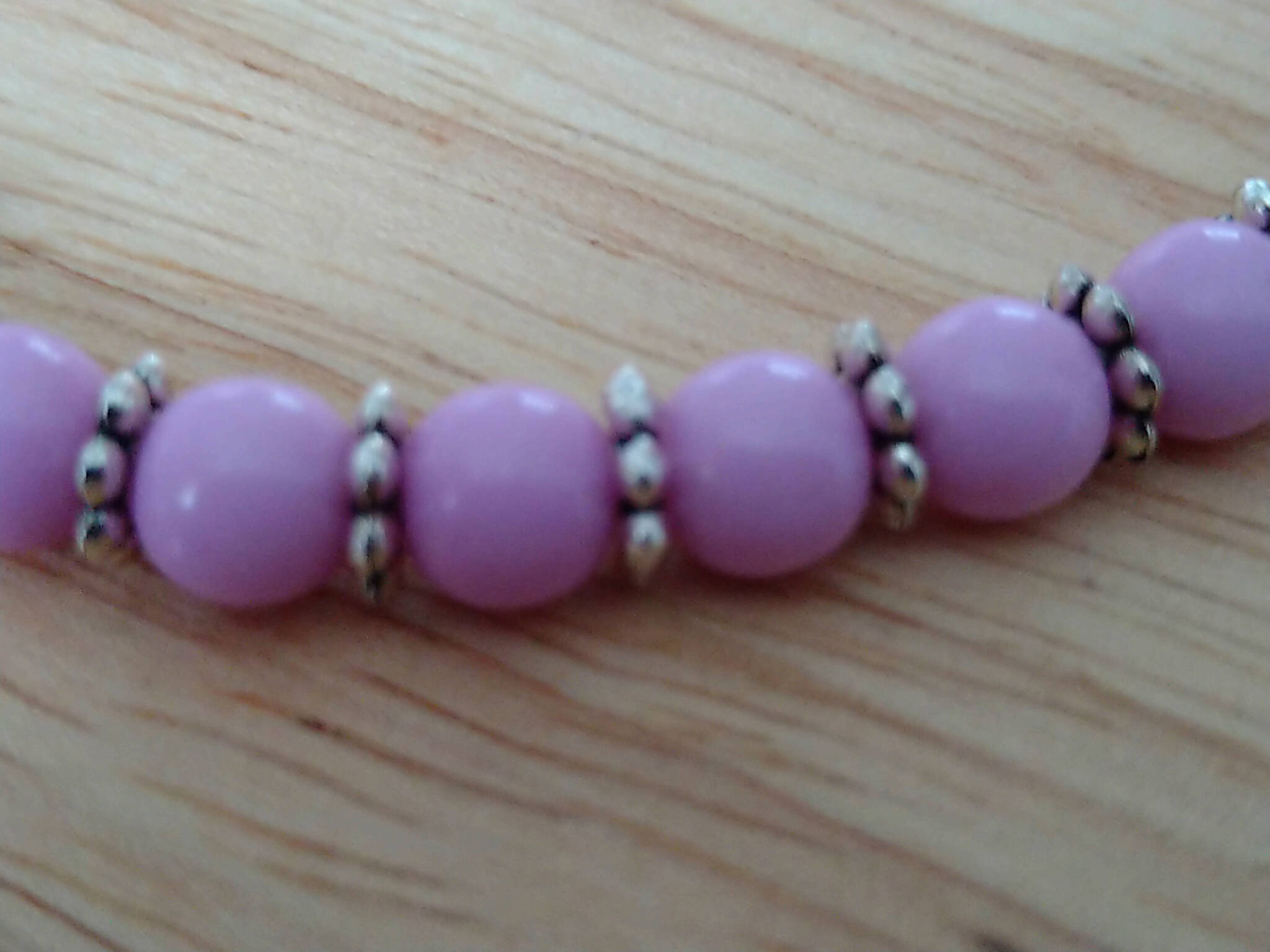 Pink coloured bracelet, handmade using recycled beads & silver coloured daisy spacers. 21cm length