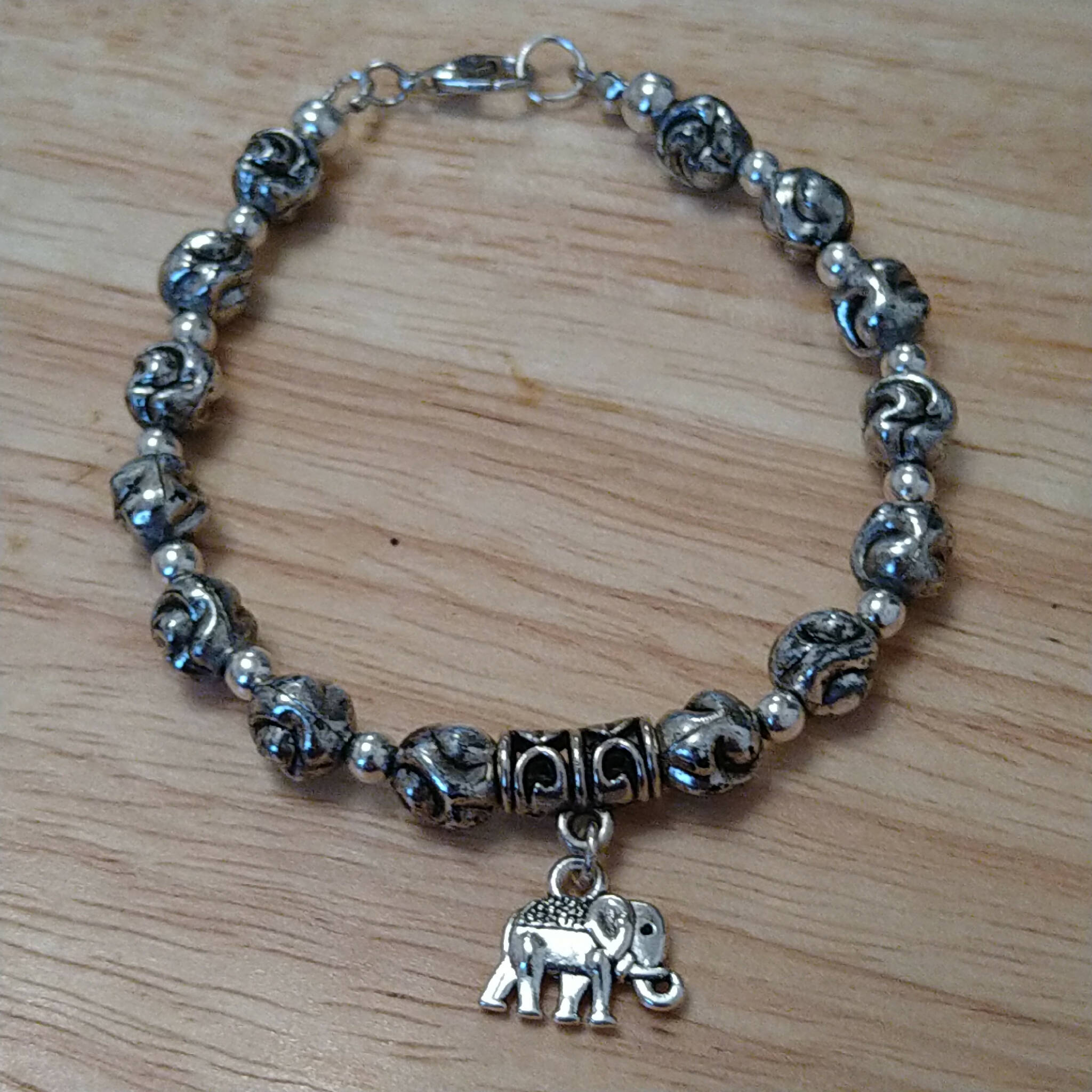 Silver coloured bracelet with elephant charm, handmade using recycled beads. 19cm length