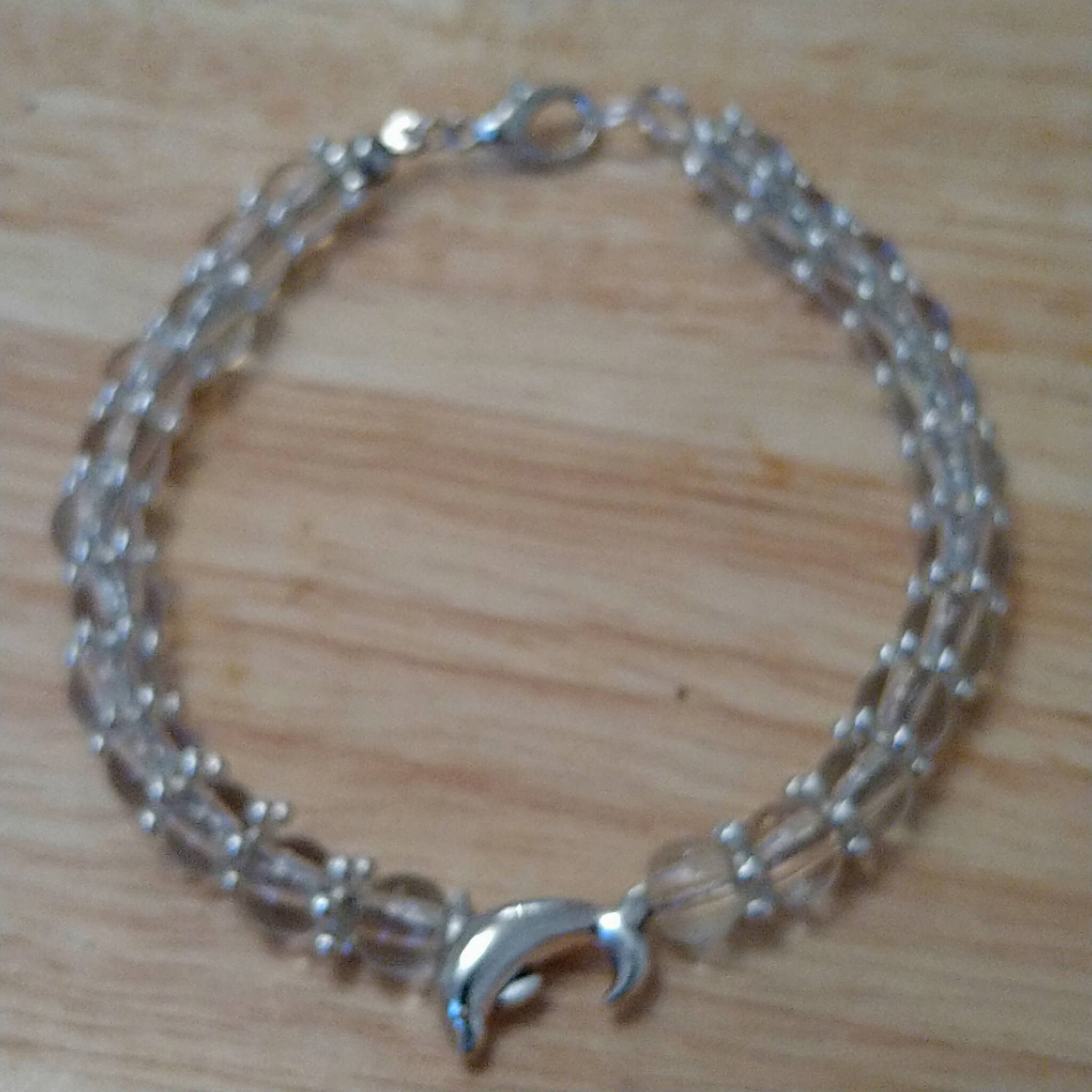 Clear bracelet with dolphin charm bead & silver coloured spacers, handmade using recycled beads. 20cm length